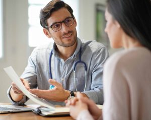 Male doctor consulting with a female patient in an office